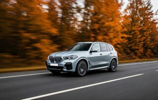 silver bmw x5 driving through a forest