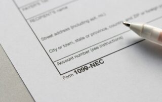 Close-up of an IRS Form 1099-NEC tax document with a pen, used as proof of income for self-employed car buyers applying for an auto loan.