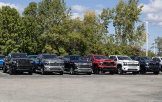 Row of Chevrolet Silverado pickup trucks parked at a dealership lot.