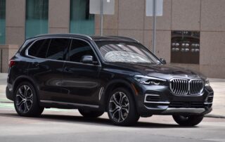 Dark gray BMW X5 luxury SUV parked on a city street.